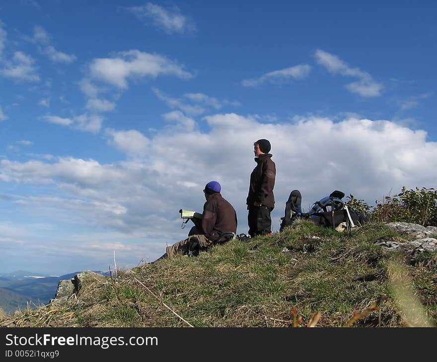 Two tourists on the summit in Caucasus mountains