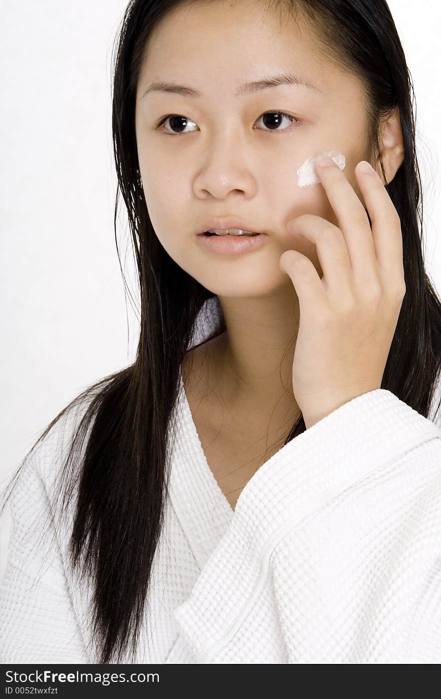 A young chinese woman applying face cream