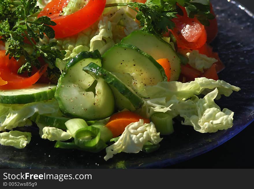 Closeup on a green salad with black background. Closeup on a green salad with black background