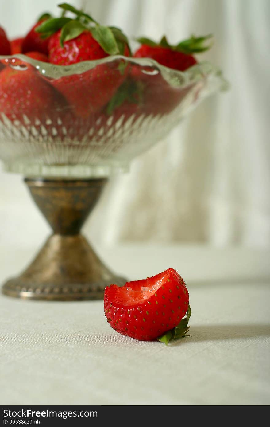 Strawberries in vintage glass bowl, off white casual setting. Strawberries in vintage glass bowl, off white casual setting