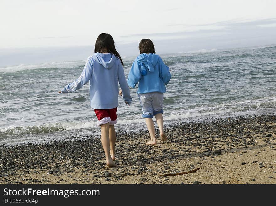 Two young girls walk down the beach.  High Res. Two young girls walk down the beach.  High Res