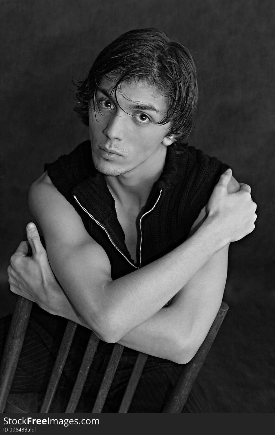 Portrait of the young man sitting on a chair. b/w. Portrait of the young man sitting on a chair. b/w