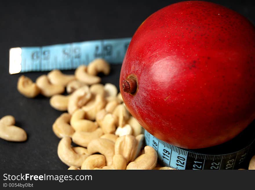 This is an image of mango, measuring tape and cashew nuts. (Please let me know where the image will be used by leaving a message in the Comments Section/See Portfolio). This is an image of mango, measuring tape and cashew nuts. (Please let me know where the image will be used by leaving a message in the Comments Section/See Portfolio)