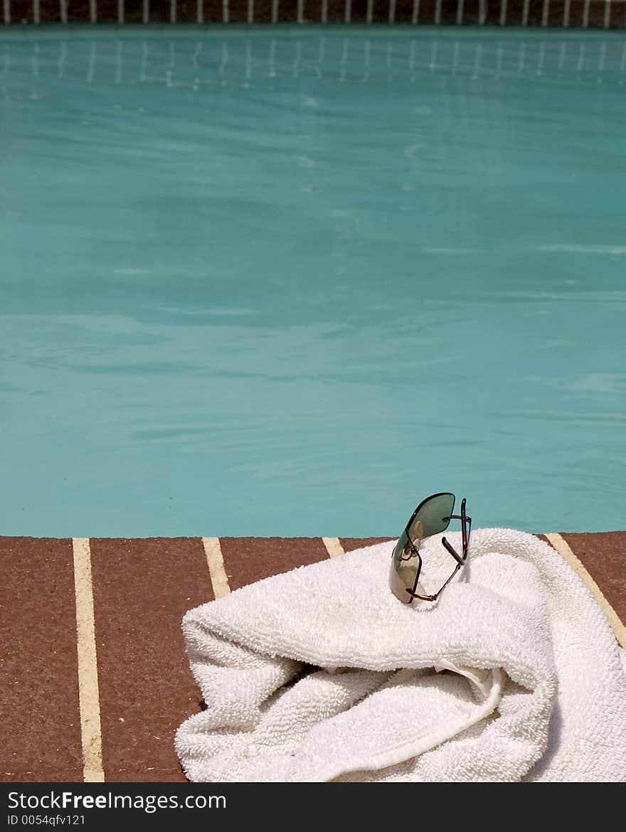 Glasses and towel beside a pool. Glasses and towel beside a pool