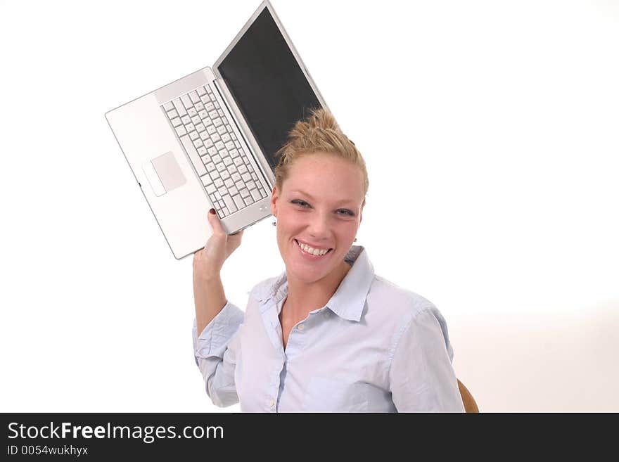 Smiling but possibly frustrated young woman seriously considering throwing her laptop computer. Smiling but possibly frustrated young woman seriously considering throwing her laptop computer