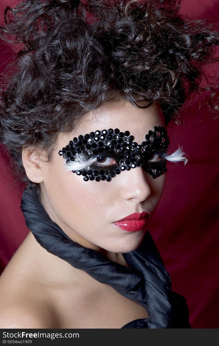 Attractive young Hispanic woman wearing a black gem mask. Attractive young Hispanic woman wearing a black gem mask