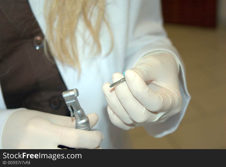 Dentist preparing drill. Dentist preparing drill