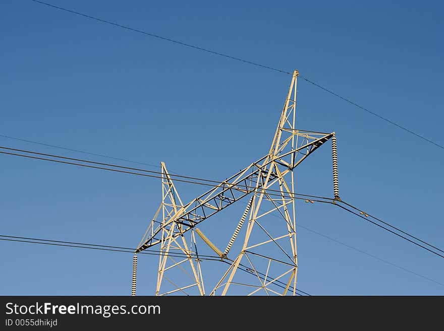 High voltage lines are held aloft by a giant power tower. High voltage lines are held aloft by a giant power tower.