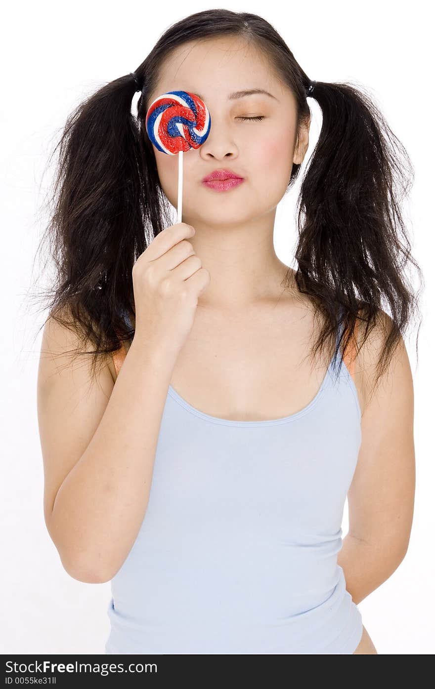 An asian teenage girl holding a colorful lollipop. An asian teenage girl holding a colorful lollipop