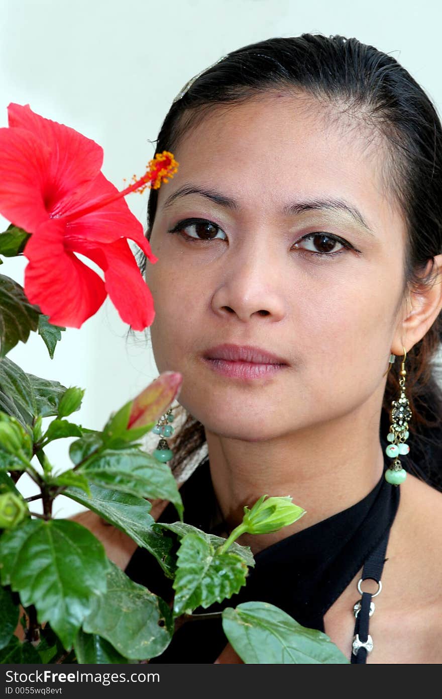 A beautiful asian girl and a red flower. A beautiful asian girl and a red flower