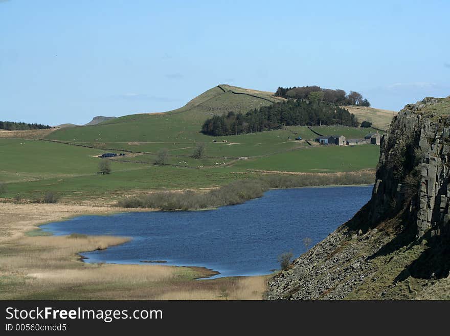 Beautiful blue waters of the lough in the rough Roman Wall country in Northumberland, England. Beautiful blue waters of the lough in the rough Roman Wall country in Northumberland, England