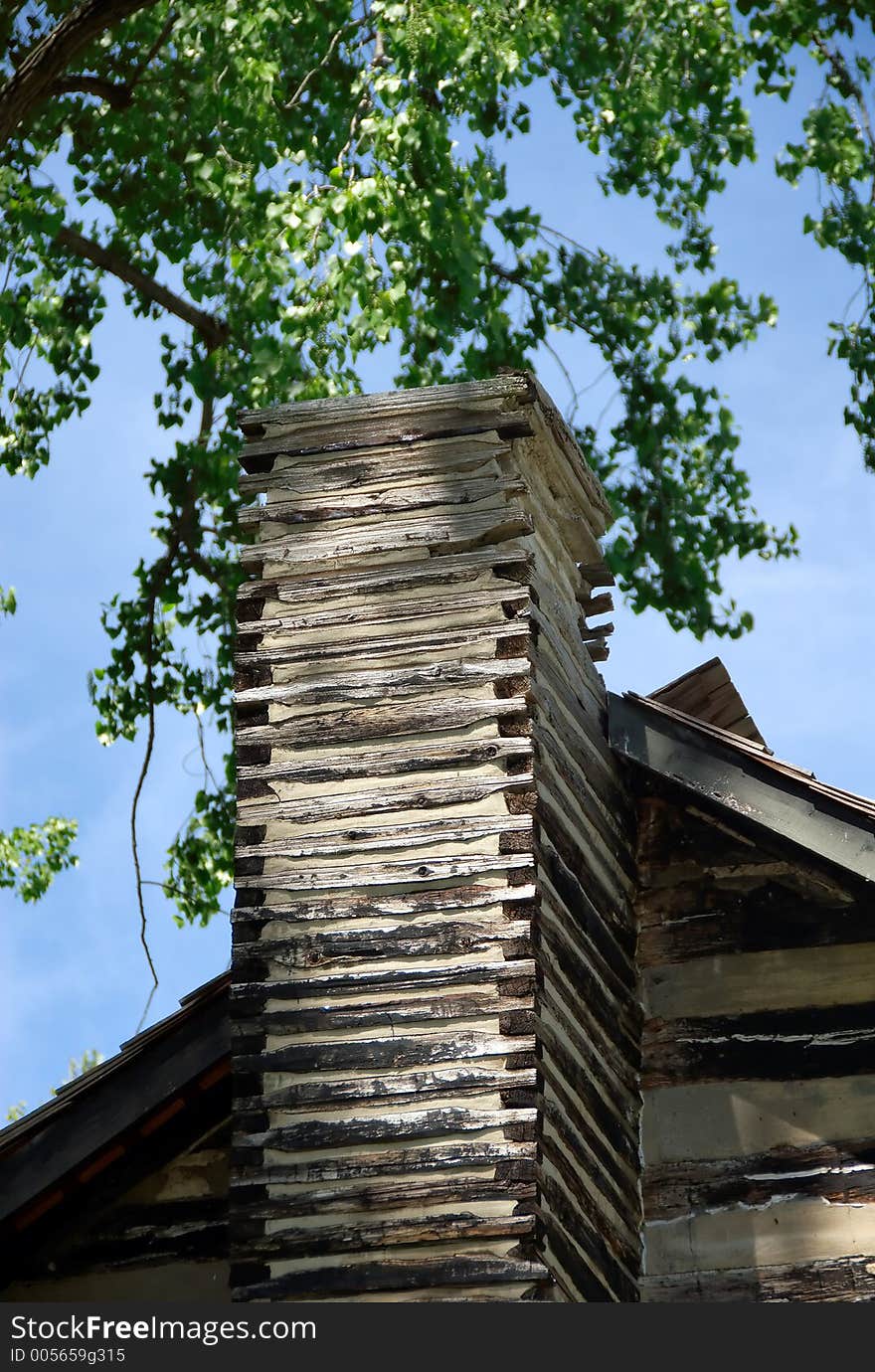 An old log cabin chimney on a spring day