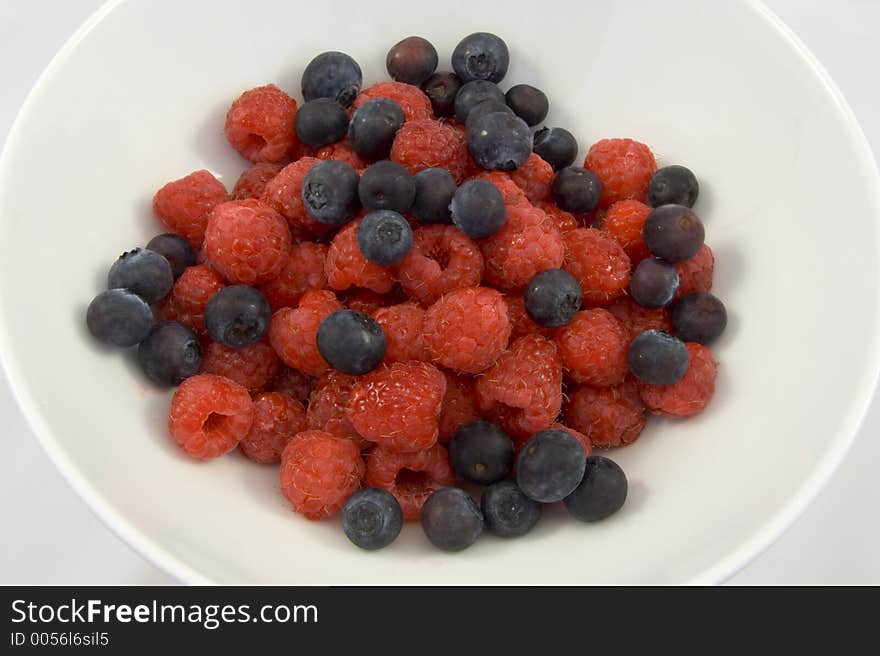 Delicious blueberry and raspberry desset in plain white bowl.