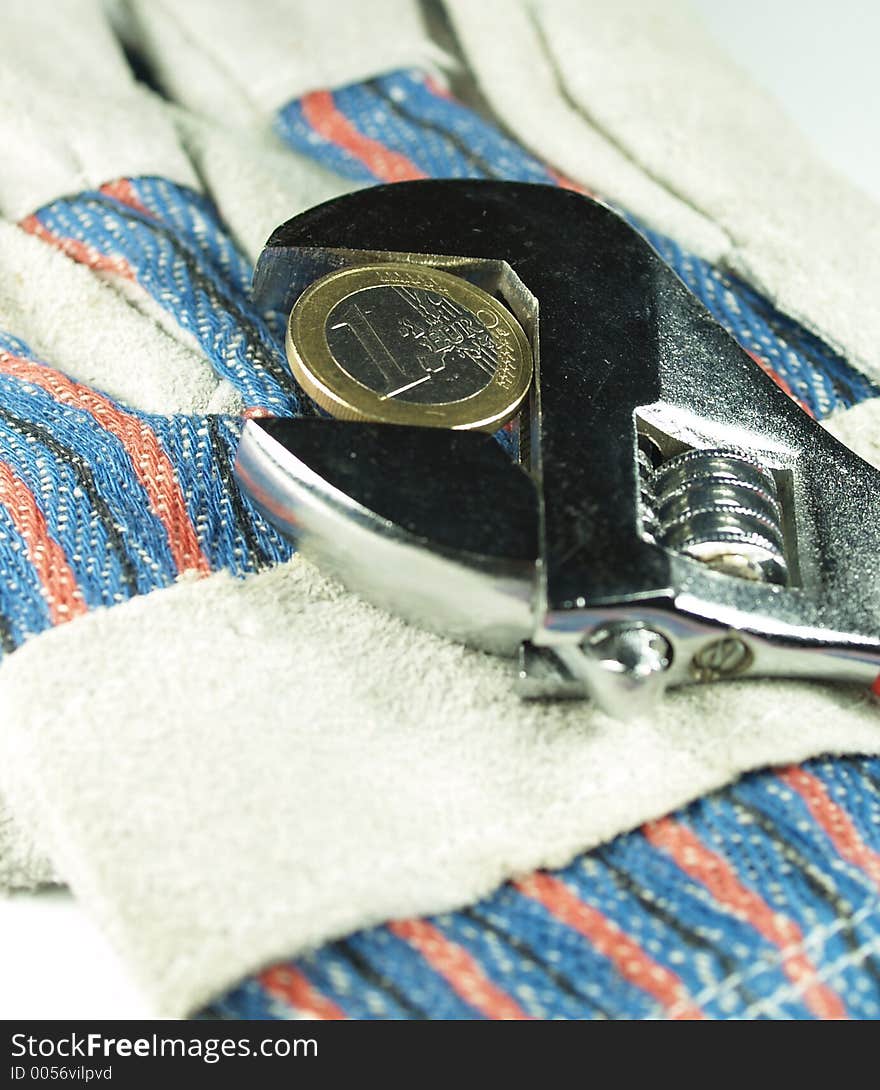 Wrentch key with euro coin on a work gloves. Wrentch key with euro coin on a work gloves