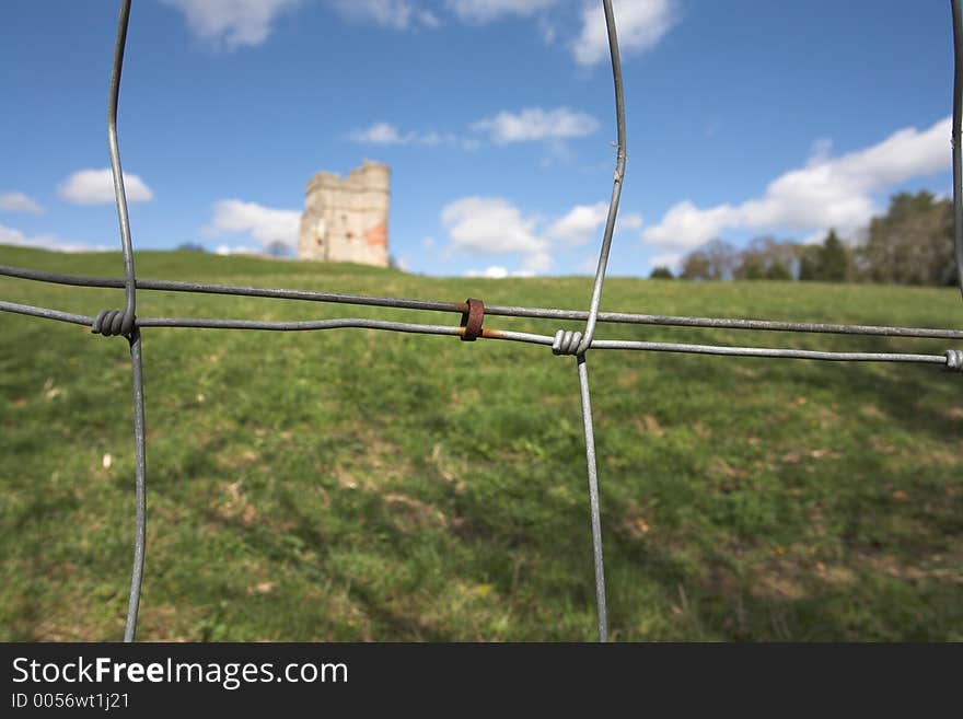 The ruins of Donnington Castle, Newbury, UK, seen through a rusty wire fence. The ruins of Donnington Castle, Newbury, UK, seen through a rusty wire fence