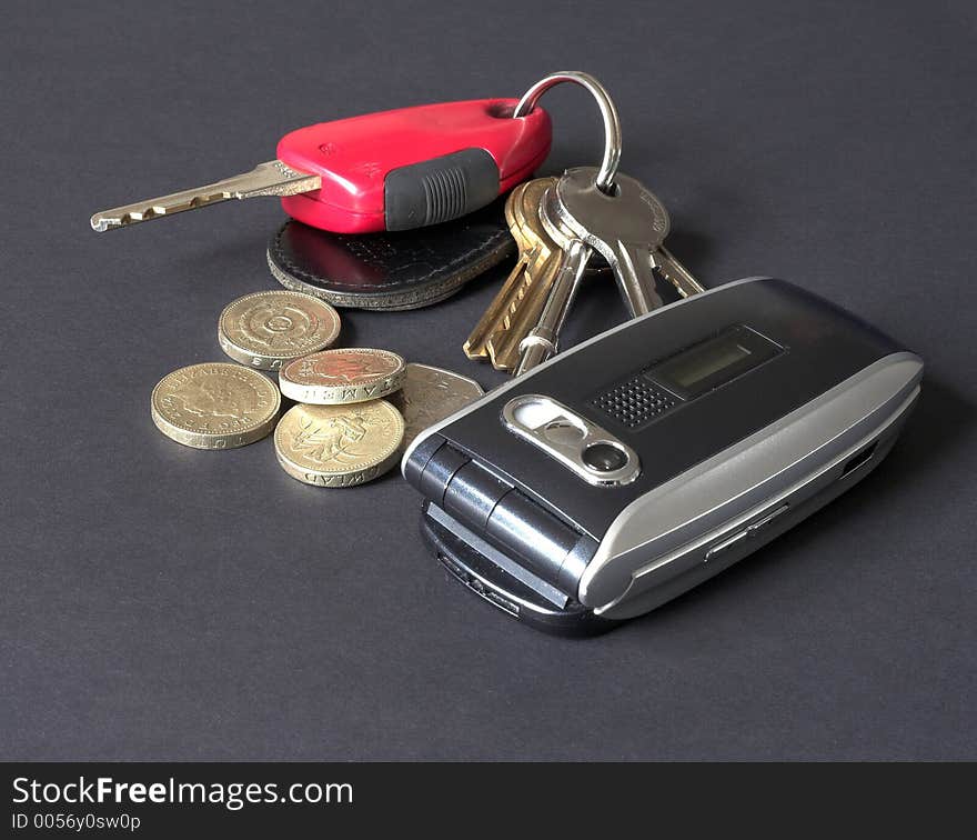 Car and house keys, coins and mobile phone. Car and house keys, coins and mobile phone