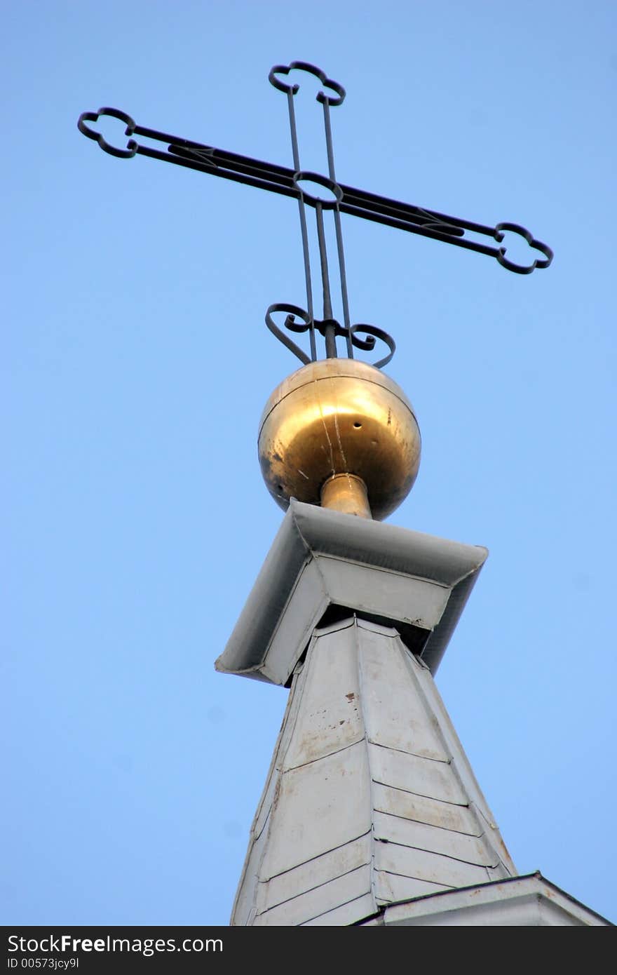 Cross on church spire against a clear blue sky