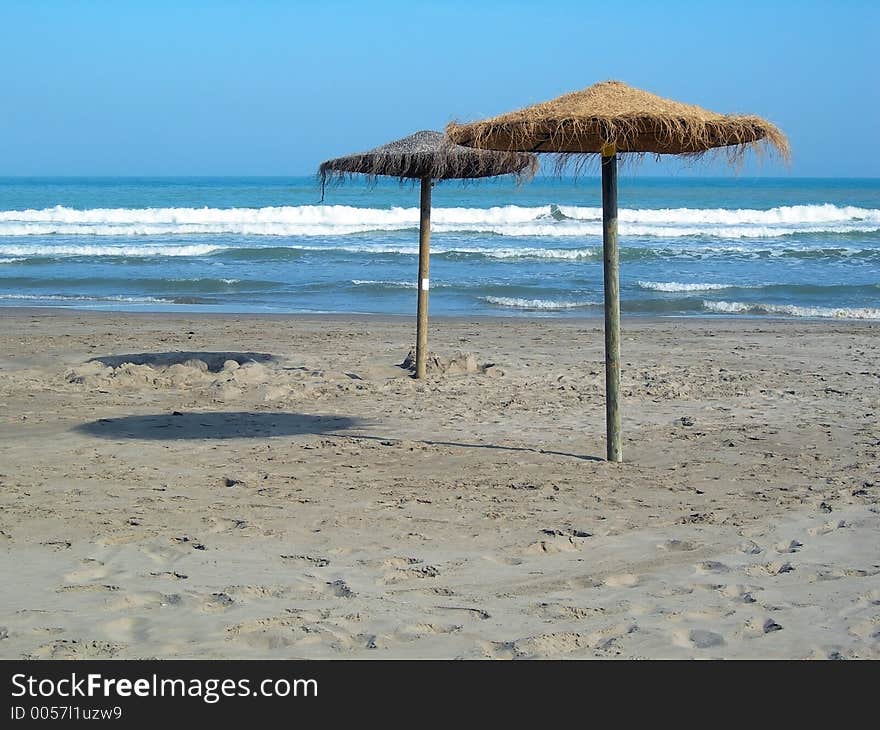 Two beach umbrellas in the sand