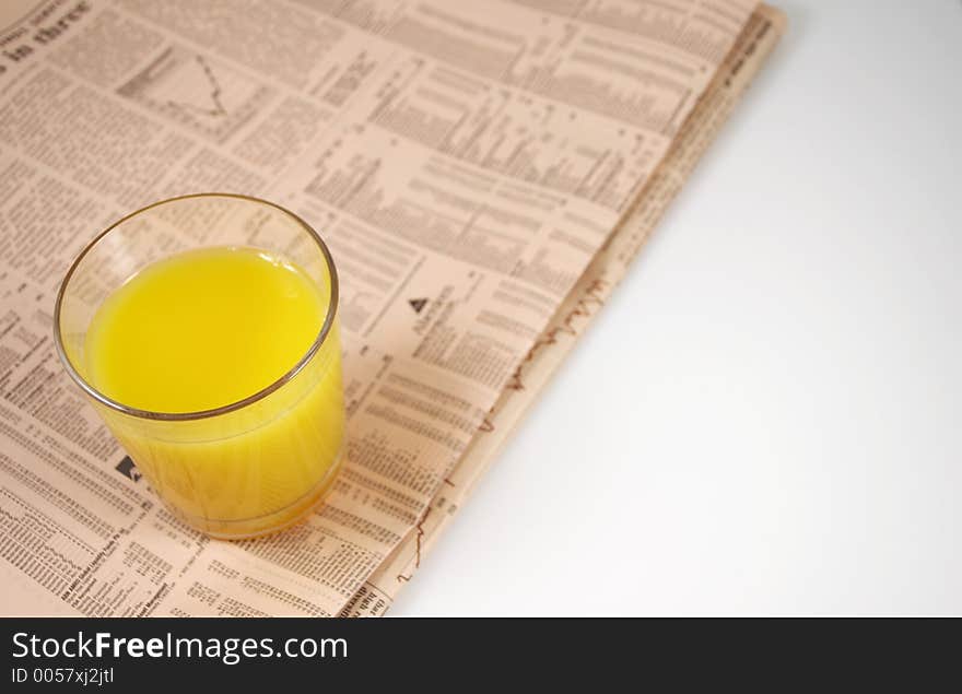 Glass of orange on newspaper