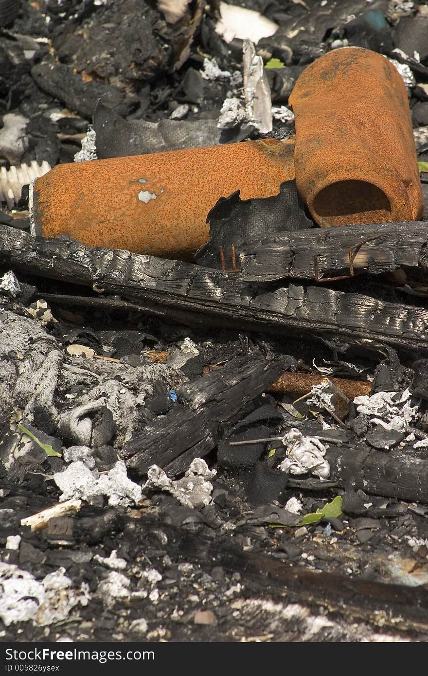 A couple of rusty cans sitting in the remains of a frire. A couple of rusty cans sitting in the remains of a frire