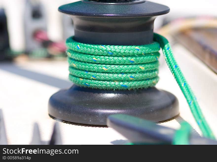 Winche with green rope in a sailboat. Winche with green rope in a sailboat