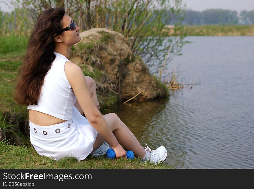 Fitness girl relaxing near a lake