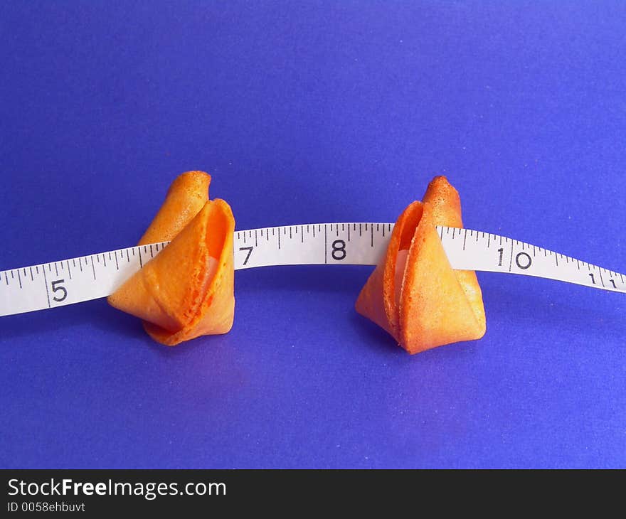 Two fortune cookies and a measuring tape (counting your fortunes). Two fortune cookies and a measuring tape (counting your fortunes)