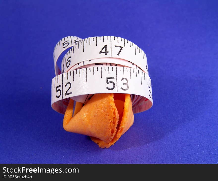 Measure tape wraps around a fortune cookie -- measuring fortune. Measure tape wraps around a fortune cookie -- measuring fortune