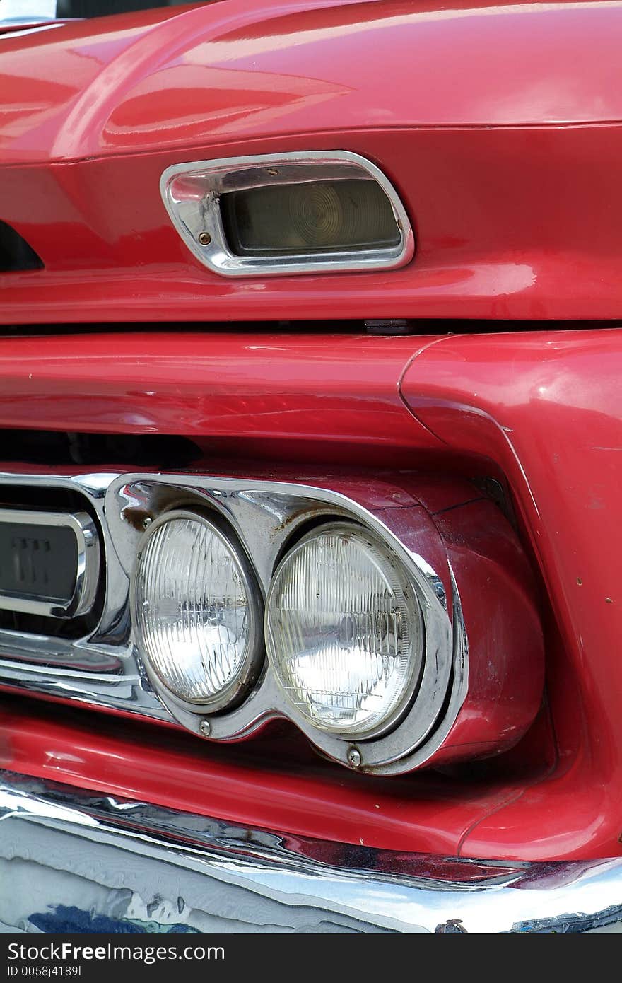 Front detail of red American pickup truck from the sixties. Front detail of red American pickup truck from the sixties