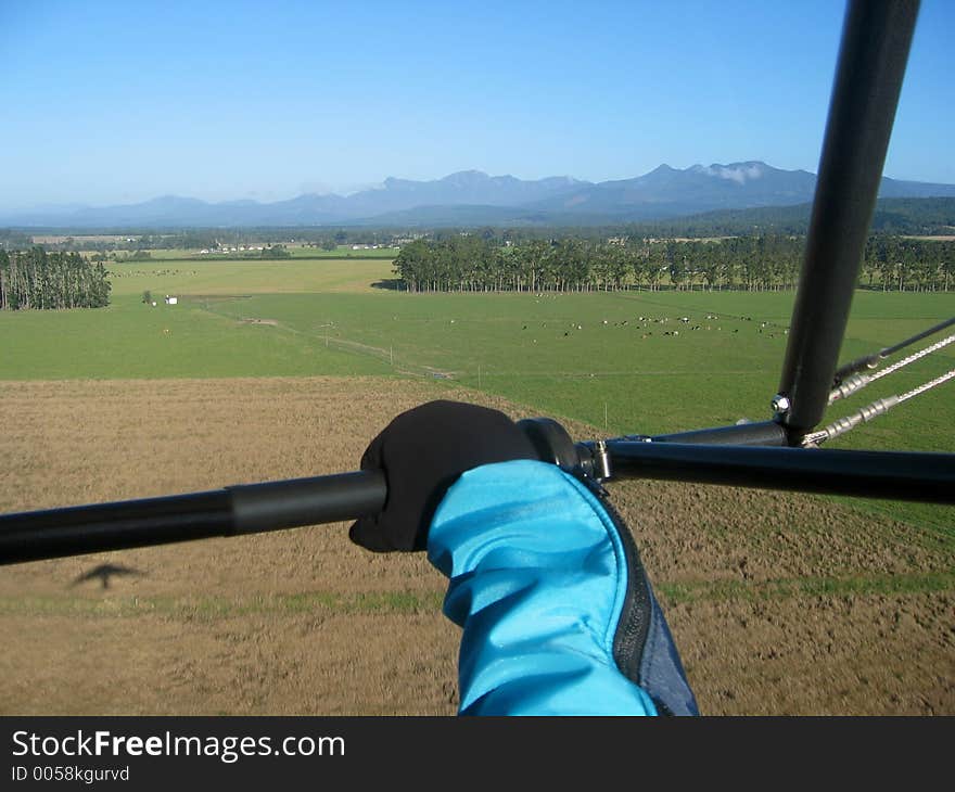 Aerial view of a farm and mountain range taken during take-off from the open air cockpit of a microlight. Aerial view of a farm and mountain range taken during take-off from the open air cockpit of a microlight.