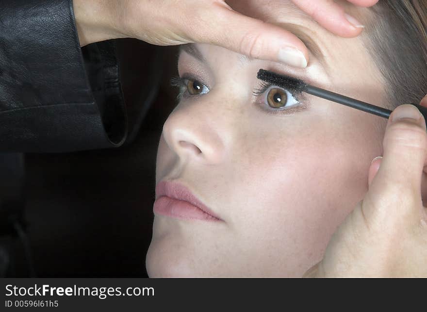 Make-up artist applying mascara to young woman?s lashes
