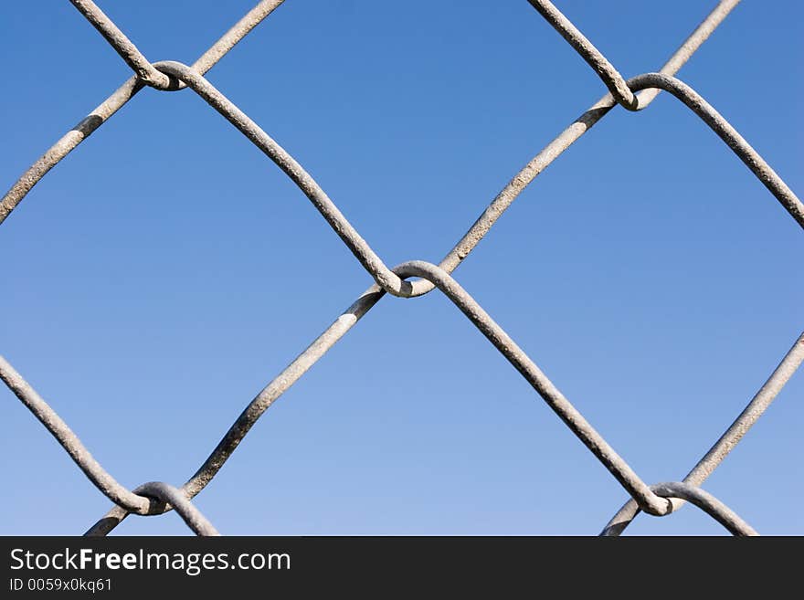 Closeup of a chin link fence with blue sky in the background. Closeup of a chin link fence with blue sky in the background