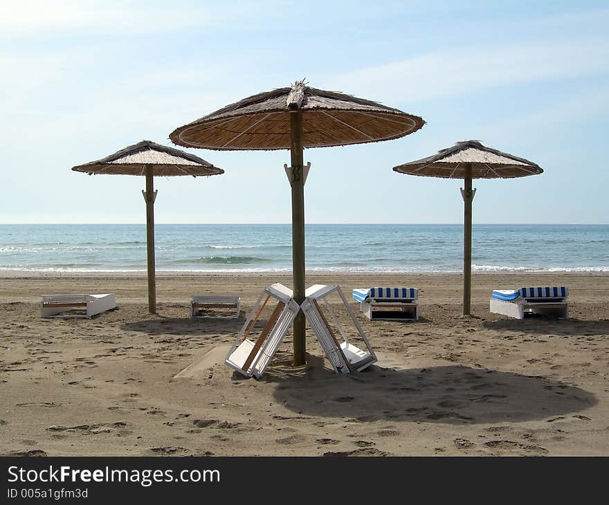 Three umbrellas with two chairs each one in the beach. Three umbrellas with two chairs each one in the beach