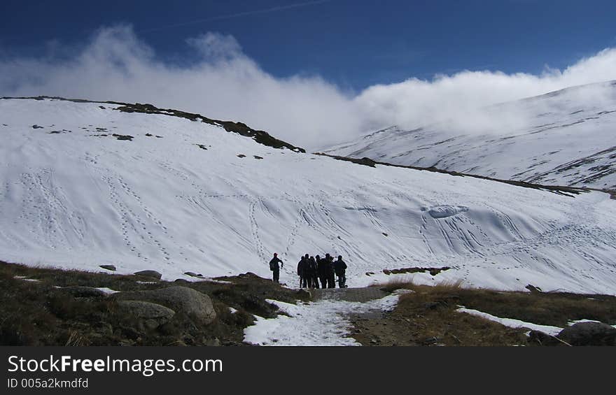 A very cool looking picture of the snowy mountains where the cloud is coming over the snowy hill and you can see the people in the background. A very cool looking picture of the snowy mountains where the cloud is coming over the snowy hill and you can see the people in the background.