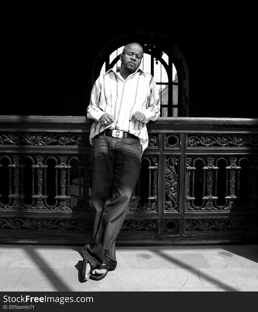 Photo of a young man standing in a window. Photo of a young man standing in a window.