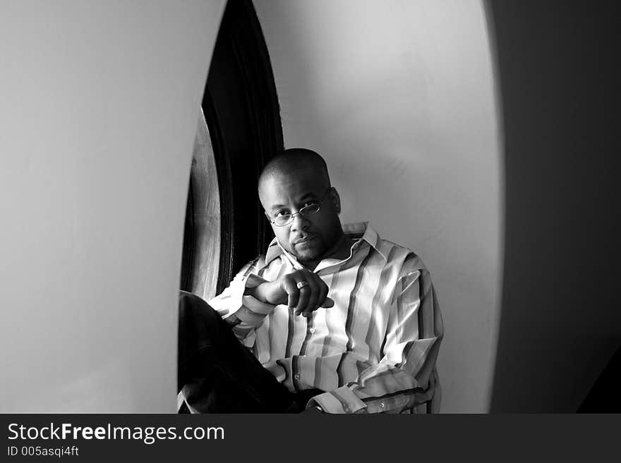 Photo of a young man standing in a window. Photo of a young man standing in a window.