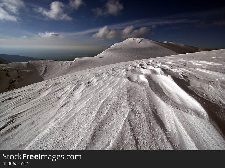 Wide angle winter landscape, wild curves and shapes in snow made by wind. Wide angle winter landscape, wild curves and shapes in snow made by wind.