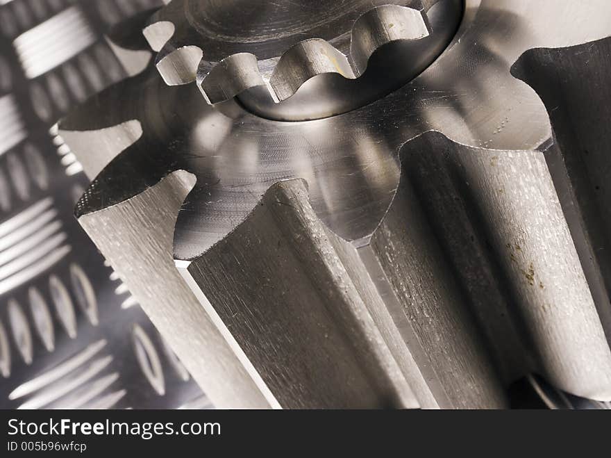 Two cogs, gears, leaning towards left in sepia-toning. Two cogs, gears, leaning towards left in sepia-toning