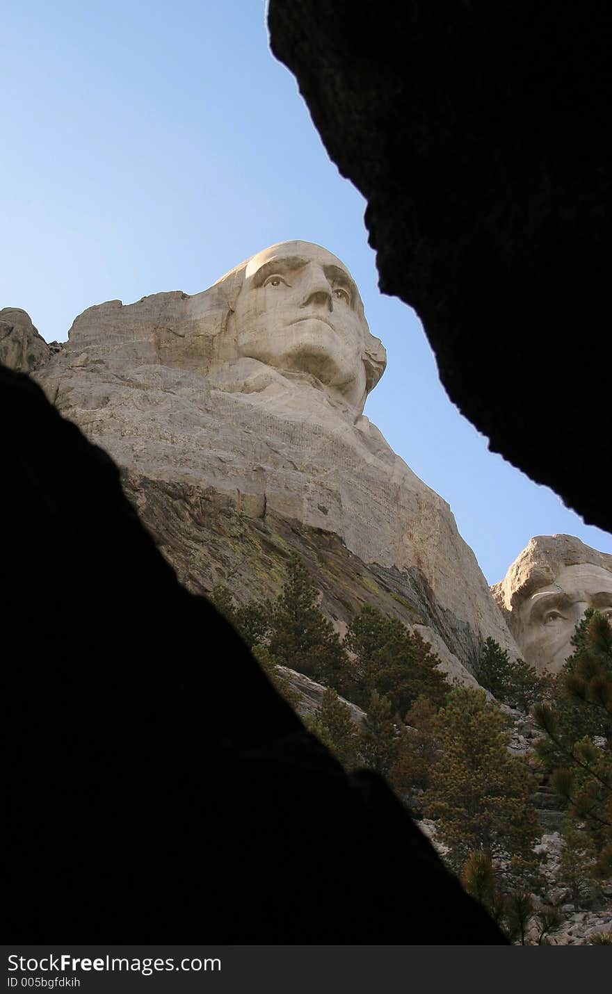 Mt Rushmore as seen looking out from inside a cave, dark areas for text. Mt Rushmore as seen looking out from inside a cave, dark areas for text