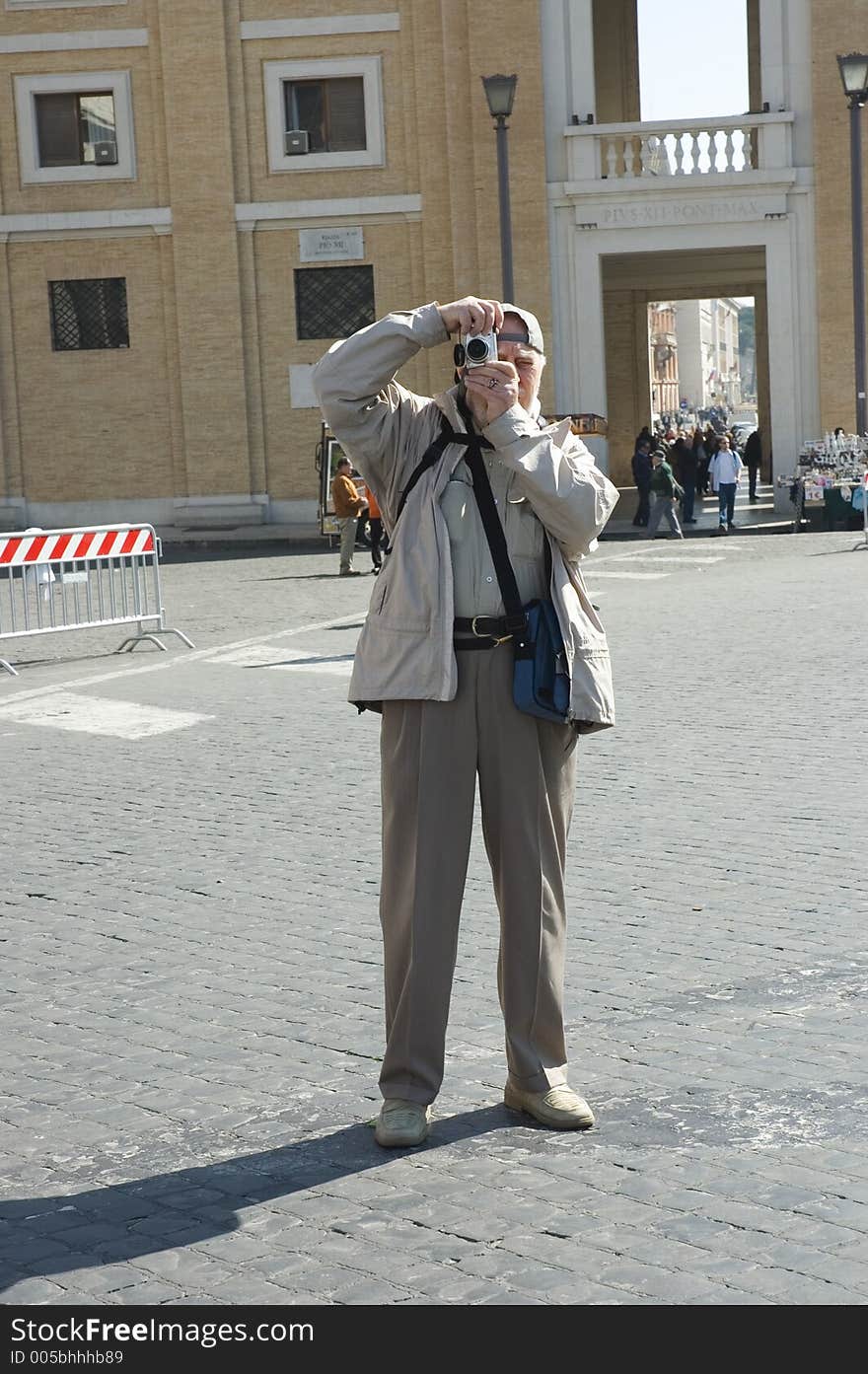 Elderly photographer tourist in piazza Pio X11, Vatican city, Rome The perfect elderly tourist with an expressively annoying smile in front of the Vatican, Rome, Saint Peter Basilica Elderly photographer tourist in Rome