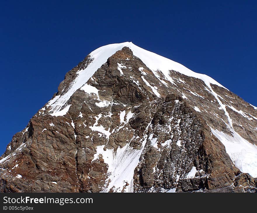 Jungfrau, Switzerland. Alps Mountains. A nice looking triangle cladded with snow and a deep blue sky as background gives pleasent feelings.