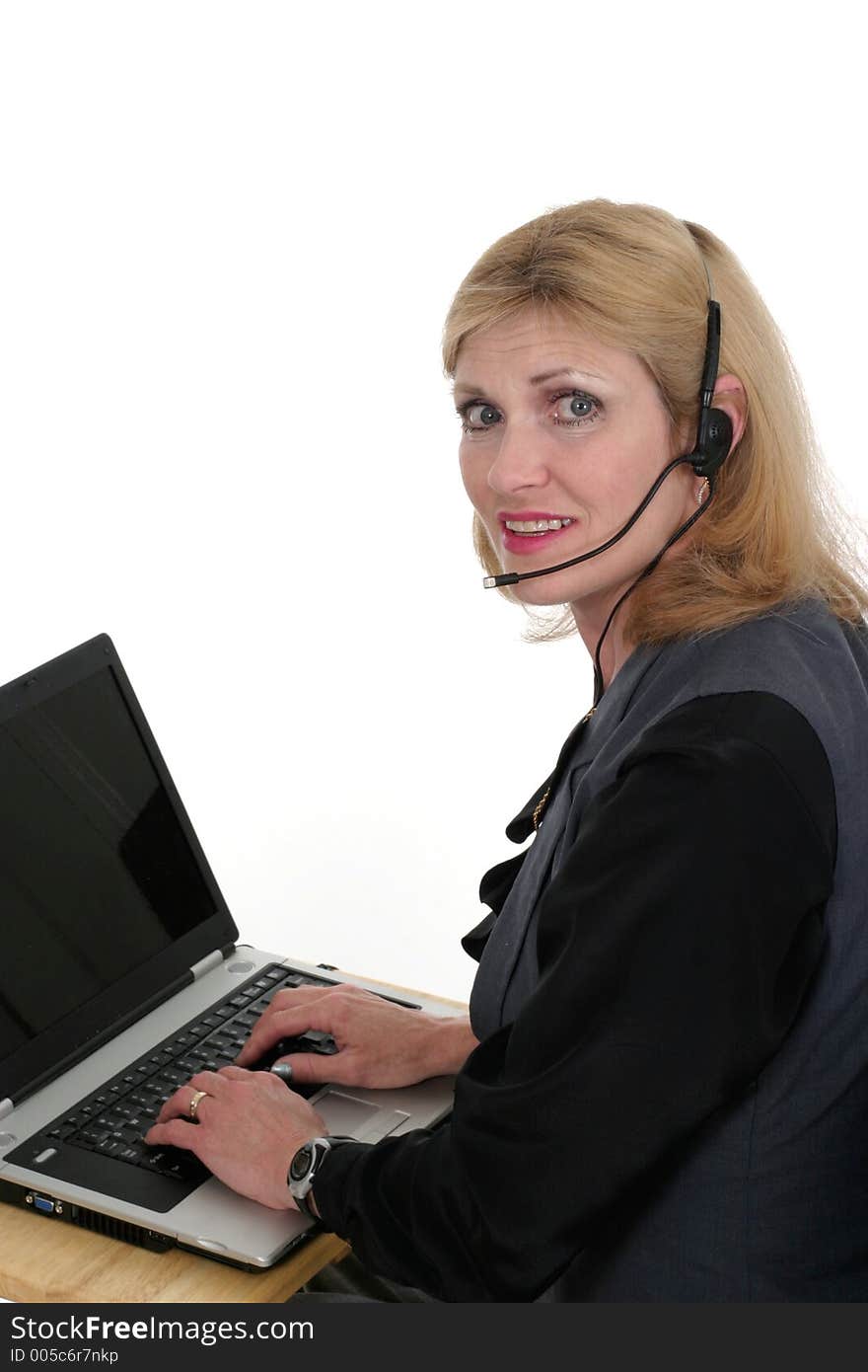 Attractive, smiling, customer service operator representative working at a computer with telephone headset. Attractive, smiling, customer service operator representative working at a computer with telephone headset