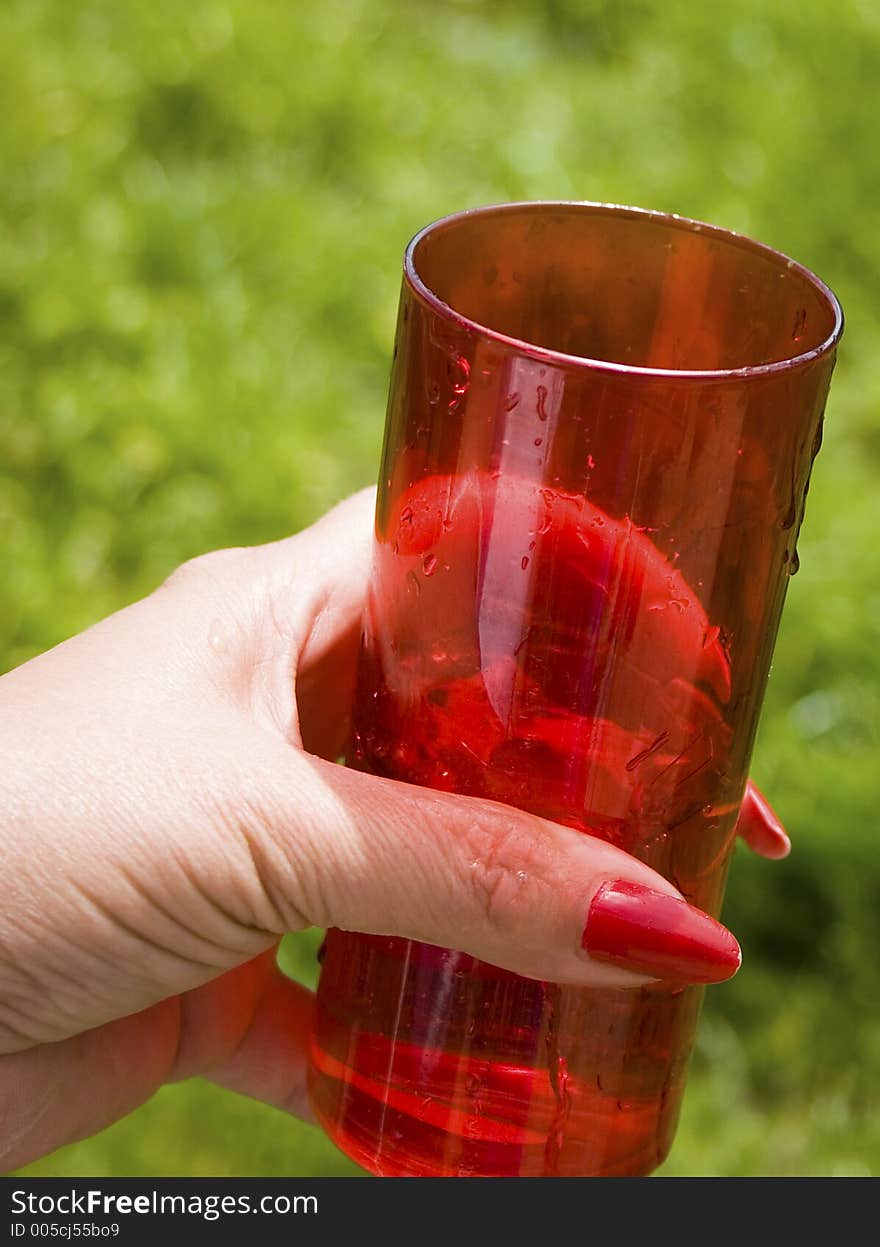 Hand holding a red glass. Hand holding a red glass