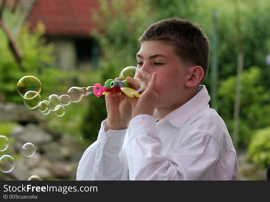 Boy blow soap-bubble in the garden . Boy blow soap-bubble in the garden