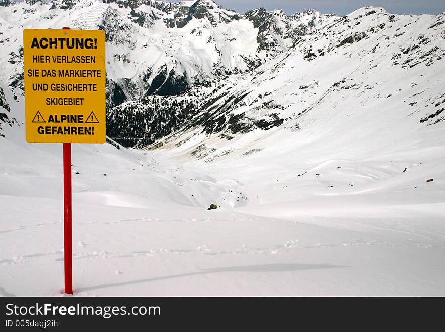 Warning about leaving marked and protected piste against a mountain background. Warning about leaving marked and protected piste against a mountain background.