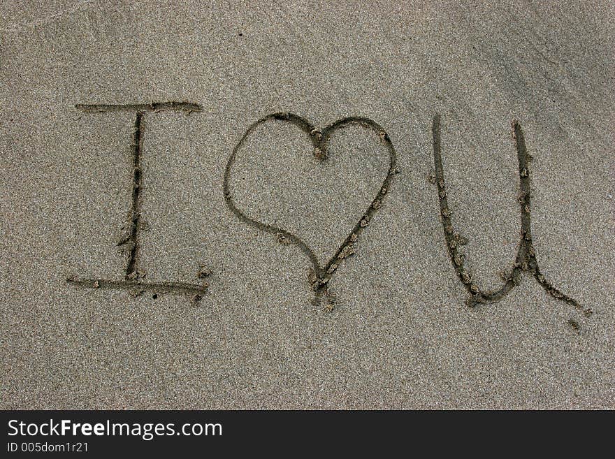 I love you written on sand with a stick. I love you written on sand with a stick