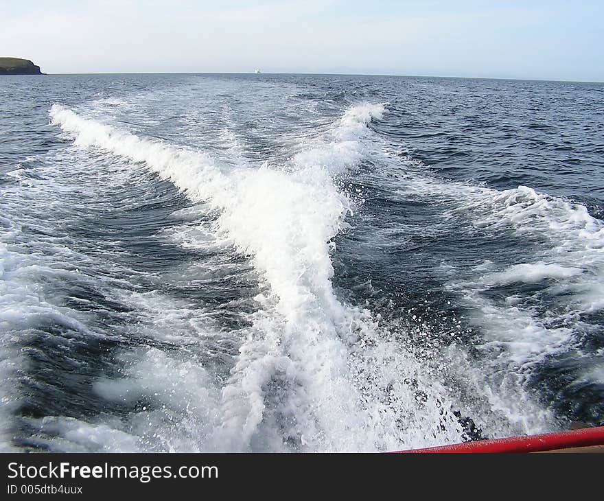 A wake and output of a powerful motor boat travelling at speed.