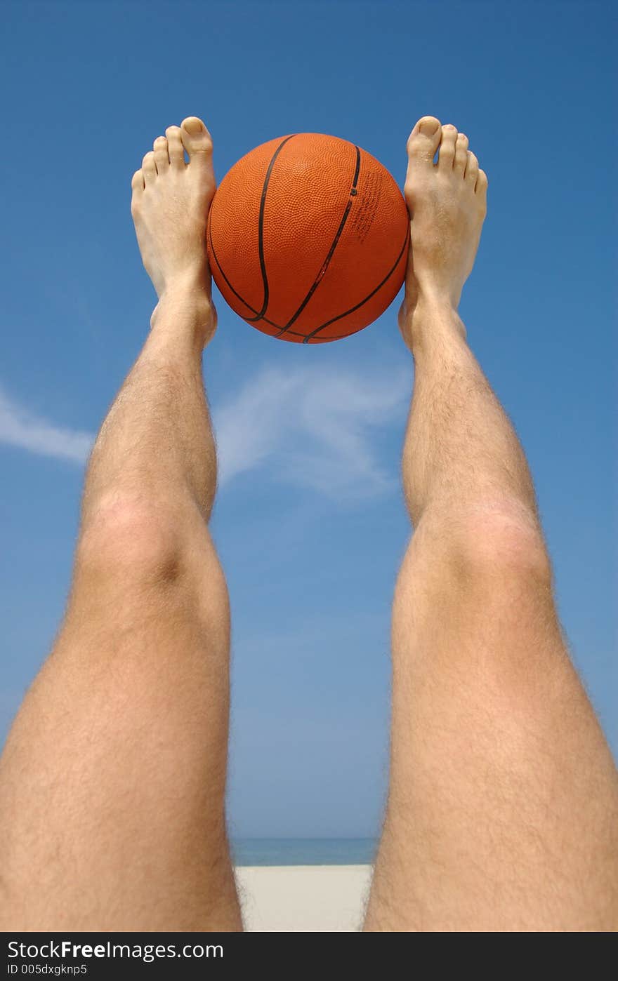 Playing basketball with legs for fun on a sandy beach during vacation. Playing basketball with legs for fun on a sandy beach during vacation.