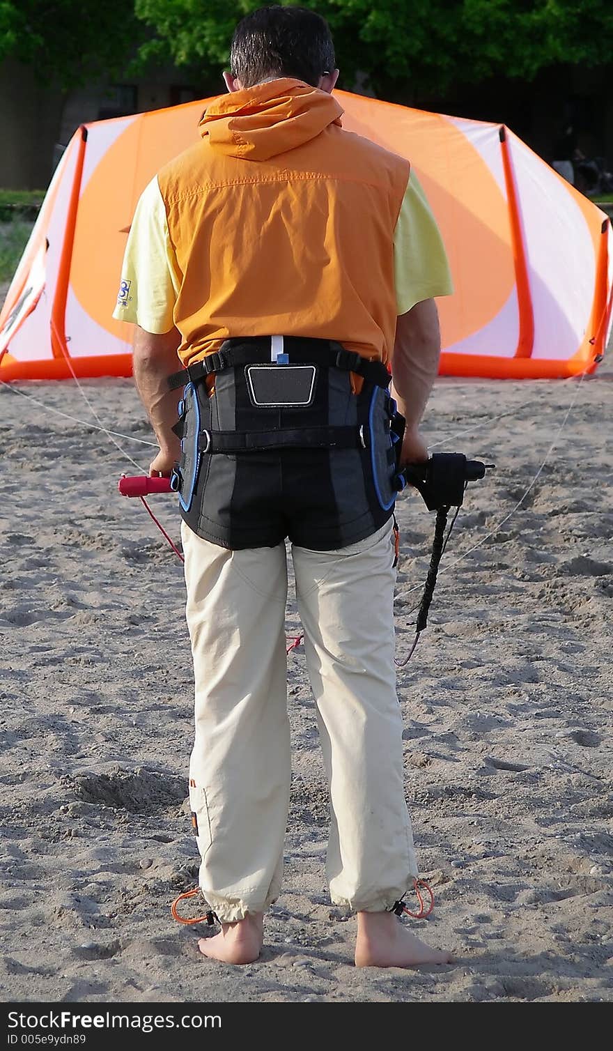 A man getting ready to fly his oversize kite. A man getting ready to fly his oversize kite.