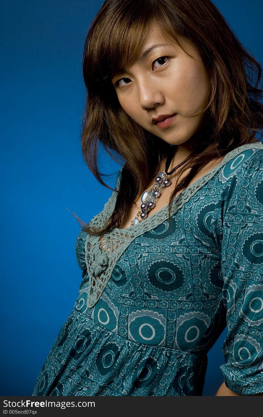 A pretty young asian woman on blue background. A pretty young asian woman on blue background